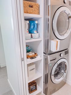 a washer and dryer in a small room with shelves on the wall next to each other