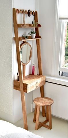 a wooden ladder is next to a mirror and stool