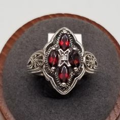 Vintage CNA Sterling with Garnets Ring, Size 8. Marked 925 CNA Thailand inside band. Stones are 4 x 3mm. Ring is 19mm wide. Weighs 0.18 ozt. We do not check prongs for wear or stones for looseness. All items are sold AS IS, noting that we are a resale shop so everything here had a previous owner! We will include flaws in the description when noted. This is one of the reasons our items are more affordable than new at a jewelry store. Are these stones real or fake? Aside from diamonds, we do not know if any gemstones are natural or synthetic. We will state on certain gemstones, that we know 100%, if they are created or fake due to their lack of inclusions. For this reason, we do not sell any diamonds without inclusions, and the larger diamonds (half ct+) are soft graded. In recent years, syn Collectible Silver Garnet Jewelry, Collectible Garnet Ring Jewelry, Collectible Garnet Ring, Ornate Garnet Rings For Anniversary, Ornate Garnet Anniversary Rings, Classic Garnet Jewelry Stamped 925, Heirloom Silver Garnet Jewelry, Anniversary Garnet Jewelry Stamped 925, Anniversary Filigree Garnet Ring