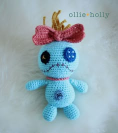 a crocheted blue stuffed animal with a pink bow on it's head