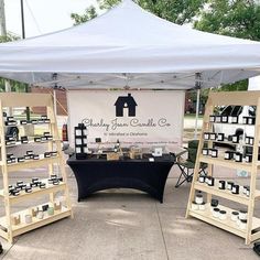 several shelves with candles under a white tent