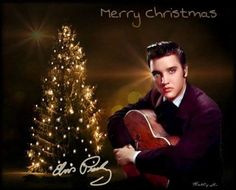 a man holding a guitar in front of a christmas tree