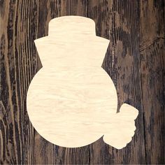 a wooden snowman cutout sitting on top of a piece of wood