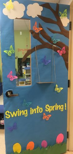 a classroom door decorated with butterflies and the words swing into spring