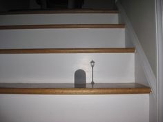 a shelf with a light on it next to some stairs