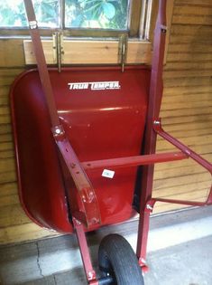 a red wagon sitting in front of a window