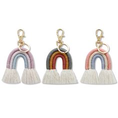 three key chains with tassels hanging from the ends and one has a rainbow on it