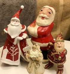 a group of santa figurines sitting on top of a white table next to each other