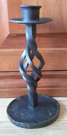 a metal candle holder sitting on top of a wooden table