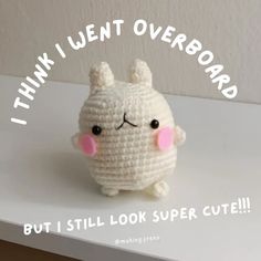 a small white stuffed animal sitting on top of a table next to a quote that reads, i think i went overboard but i still look super cute