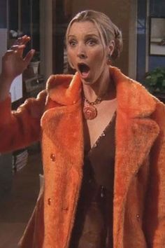 a woman in an orange coat making a surprised face