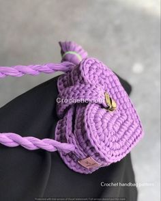 a purple crocheted bag on top of a mannequin's head