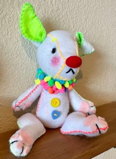 a white stuffed animal sitting on top of a wooden table