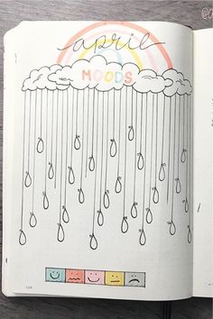 an open notebook with rain drops on the pages and rainbows in the sky above it