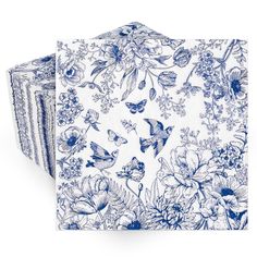 three napkins with blue and white floral designs on them, one is folded to the side