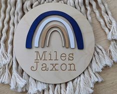 a wooden plaque with a rainbow and the words miles jaxon written on it