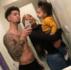 a man taking a selfie in the bathroom with his daughter and baby on his lap