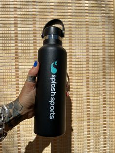 a woman is holding a black water bottle