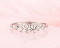 a three stone diamond ring on a pink background