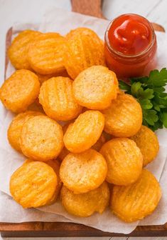 some fried food is sitting on a napkin next to a jar of ketchup