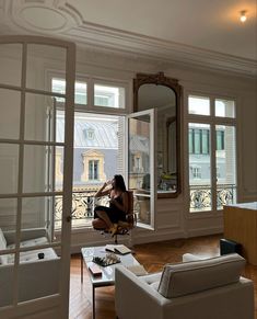 a woman sitting on a chair in front of a window