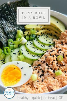 a bowl filled with rice, cucumber and an egg next to sliced green onions