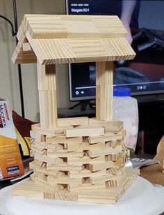 a bird house made out of wood sitting on top of a table