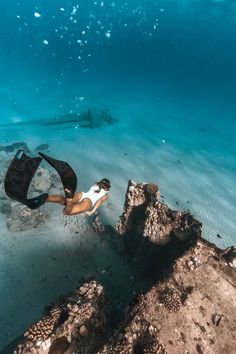 a woman is swimming in the ocean with her surfboard