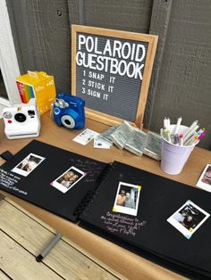 a table topped with pictures and writing on black paper next to a chalkboard sign that says polaroid guestbook