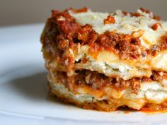 two pieces of lasagna stacked on top of each other with cheese and sauce