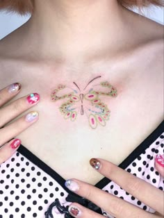 a woman's chest with butterfly tattoos on her left side and polka dots around the breast