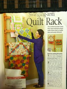 a woman standing in front of a quilt rack