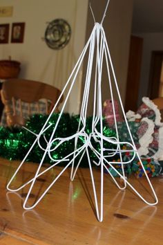 a white sculpture sitting on top of a wooden table next to a green christmas tree