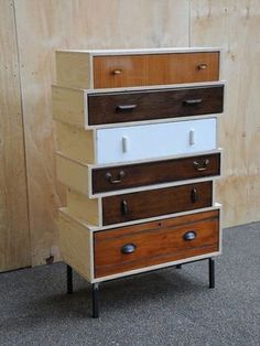 a stack of drawers sitting in front of a wooden wall