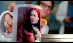 a person holding up a coffee mug with a photo on it