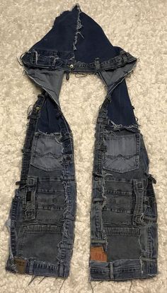 an old pair of jeans with holes in the bottom and sides are laying on carpet