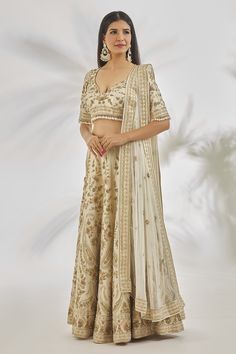 Ivory can can attached lehenga featuring all over zardozi along with pearl embroidered paisley and floral patterns. Comes with matching padded blouse featuring pearl embellished floral motifs highlighted with pearl tassels and matching pearl embroidered dupatta.
Components: 3
Pattern: Embroidered
Type Of Work: Zardozi,Pearl
Neckline: Cut-out
Sleeve Type: Half
Fabric: Dupion Silk
Color: Ivory
Other Details: 
Attached lining
Cut-out back detail
Closure:
Blouse: Back hook
Lehenga: Side tasselled dr Off White Raw Silk Lehenga For Reception, Cream Raw Silk Choli For Reception, Bollywood Style Cream Choli With Pallu, Cream Choli With Pallu For Reception, Unstitched Cream Lehenga For Reception, Cream Bollywood Lehenga With Traditional Drape, Beige Lehenga With Dupatta In Traditional Drape, Off White Choli With Pallu For Reception, Traditional Drape Raw Silk Cream Choli