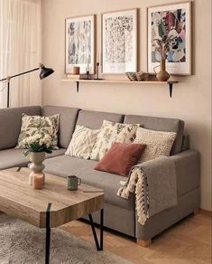 a living room filled with furniture and pictures hanging on the wall above a coffee table