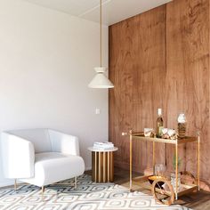 a chair and table in a room with wood paneling on the wall behind it