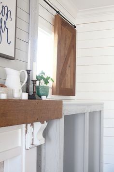 a white fireplace mantel topped with a wooden mantle