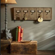 a lamp and some books are on a table next to a wall mounted coat rack