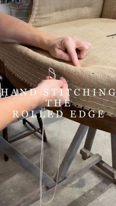 someone is working on an upholstered chair with the words hand stitching the rolled edge