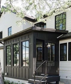 a small house with stairs leading to the front door and side windows on both sides