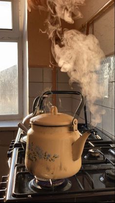 a tea pot is on the stove with steam rising from it