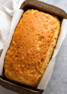 a loaf of bread sitting in a pan on top of a table next to a napkin