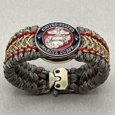 "This is an officer Marine Corps paracord bracelet. Silver and gold plated Eagle Globe and Anchor. Makes a perfect USMC gift for any veteran or active duty Marine. Marine Moms and Dads will love this bracelet too. Chesty Puller approved.  *Silver & gold plated officer Eagle Globe & Anchor *1 1/4\" wide USMC medallion. Only 9mm thick *1 1/8\" wide weave *Very sturdy and durable *Quality gold Cobra style tactical buckle *Very comfortable *I am an official USMC licensee; license #H294-23 *Handmade in the USA I weave my proprietary EGA bead INTO the bracelet which makes this a very sturdy bracelet! The baked enamel paint and the silver and gold plating of the EGA are very scratch resistant. The bead's baked enamel finish is painted in the official USMC colors; PMS289C blue and PMS187C red and Adjustable Gold Paracord Bracelet, Adjustable Gold Paracord Bracelets, Chesty Puller, Usmc Gifts, Eagle Globe Anchor, Marine Veteran, 550 Cord, Marine Mom, Semper Fi