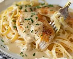 a white plate topped with pasta and chicken covered in gravy