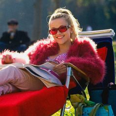 a woman sitting in a chair wearing sunglasses