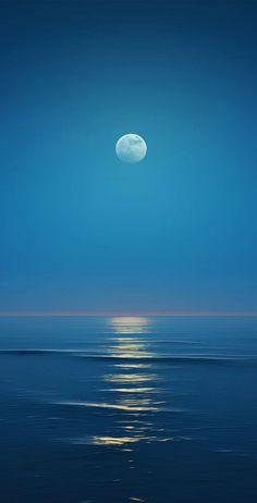 the moon is reflected in the water at night with blue sky and ocean below it