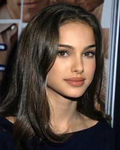 a close up of a person with long hair and brown eyeshadow wearing earrings